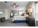 This primary bedroom features a ceiling fan, carpeted floor, bedside tables with lamps, and a television set at 8470 Imperial Cir, Palmetto, FL 34221