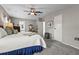 This primary bedroom features a ceiling fan, carpeted floor, bedside tables with lamps, and ensuite bathroom at 8470 Imperial Cir, Palmetto, FL 34221