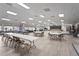 Versatile meeting room for social events featuring neutral colors, a stage, wood floors, tables and chairs at 8470 Imperial Cir, Palmetto, FL 34221