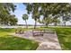 Outdoor picnic area showcases communal gathering space with mature landscaping, a lake view, and sunny skies at 8470 Imperial Cir, Palmetto, FL 34221