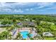 Overhead view of community clubhouse and pool, featuring abundant lounge seating, palm trees, and tropical landscaping at 8827 Manor Loop # 208, Lakewood Ranch, FL 34202