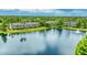 Overhead angle of a lakefront property nestled among trees, providing a tranquil view at 8827 Manor Loop # 208, Lakewood Ranch, FL 34202