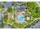 Aerial view of the community with pool, spa, clubhouse, and tennis court surrounded by lush landscaping at 8827 Manor Loop # 208, Lakewood Ranch, FL 34202