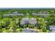Aerial view showcasing the community clubhouse, a swimming pool, manicured landscaping, and surrounding townhouses at 8827 Manor Loop # 208, Lakewood Ranch, FL 34202