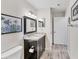 Bright bathroom with granite countertop vanity, mirror, vanity, and views to an adjacent room at 8827 Manor Loop # 208, Lakewood Ranch, FL 34202