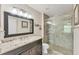 Bathroom showcasing a granite countertop vanity, large mirror, and a glass-enclosed walk-in shower at 8827 Manor Loop # 208, Lakewood Ranch, FL 34202