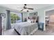 Bedroom with a ceiling fan, serene view from the window, and a cozy bed with patterned bedding at 8827 Manor Loop # 208, Lakewood Ranch, FL 34202