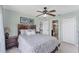 Airy bedroom with a ceiling fan, ensuite bathroom, closet, and comfortable bed with decorative pillows and bedding at 8827 Manor Loop # 208, Lakewood Ranch, FL 34202