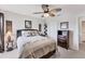 Bedroom with a ceiling fan, closet, dresser, and a cozy bed with patterned bedding and decorative pillows at 8827 Manor Loop # 208, Lakewood Ranch, FL 34202