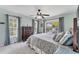 Bright bedroom featuring a ceiling fan, large windows, and a comfortable-looking bed with decorative pillows at 8827 Manor Loop # 208, Lakewood Ranch, FL 34202
