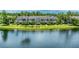 Waterfront condo buildings with lush landscaping and palm trees offer serene living at 8827 Manor Loop # 208, Lakewood Ranch, FL 34202