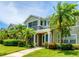 Charming condo building with colorful landscaping, tropical palms, and a welcoming entrance at 8827 Manor Loop # 208, Lakewood Ranch, FL 34202