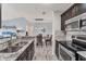 Modern kitchen with stainless steel appliances, granite countertops, and an open layout to the dining area at 8827 Manor Loop # 208, Lakewood Ranch, FL 34202