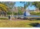 Community picnic area with tables, umbrellas, grill, and a view of the pond with a water fountain feature at 8827 Manor Loop # 208, Lakewood Ranch, FL 34202