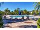 Community pool with lounge chairs surrounded by palm trees providing shade and tropical vibes on a sunny day at 8827 Manor Loop # 208, Lakewood Ranch, FL 34202