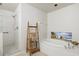 Well-lit bathroom featuring a soaking tub, walk-in shower, and towel ladder at 1000 San Lino Cir # 1032, Venice, FL 34292