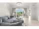 Living room features a gray sofa, tiled floors, and sliding glass doors to the outside balcony at 1000 San Lino Cir # 1032, Venice, FL 34292
