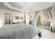 Main bedroom with tray ceiling, tiled floor, and sliding glass doors to a private balcony at 1000 San Lino Cir # 1032, Venice, FL 34292