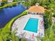 Aerial view of a pool featuring lounge chairs, a lake, and lush landscaping at 1000 San Lino Cir # 1032, Venice, FL 34292