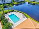 Aerial view of a community pool with lounge chairs by the lake at 1000 San Lino Cir # 1032, Venice, FL 34292