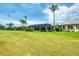 Backyard view of home with screened in porch, palm trees, and view of the golf course at 1017 Tuscany Blvd, Venice, FL 34292