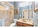 Bathroom with wood vanity, walk-in shower, and blue floral wallpaper at 1017 Tuscany Blvd, Venice, FL 34292