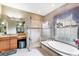 Well-lit bathroom featuring a large tub, glass shower, and vanity with a makeup area at 1017 Tuscany Blvd, Venice, FL 34292