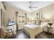 Bright bedroom with hardwood floors, a ceiling fan, and a chair in the corner at 1017 Tuscany Blvd, Venice, FL 34292