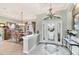 Welcoming foyer features detailed tile, half wall, hanging chandelier and view into dining area at 1017 Tuscany Blvd, Venice, FL 34292