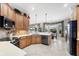 Open kitchen featuring wood cabinets, tile floors, stainless appliances and breakfast nook with large windows at 1017 Tuscany Blvd, Venice, FL 34292
