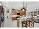 Open kitchen features wooden cabinets, updated appliances, bar top seating and tile backsplash at 1017 Tuscany Blvd, Venice, FL 34292