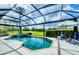 Screened-in pool and spa area featuring golf course views, lush landscaping and lounge chairs at 1017 Tuscany Blvd, Venice, FL 34292