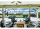 Covered lanai features seating area with beautiful pool and golf course views at 1017 Tuscany Blvd, Venice, FL 34292