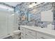 Modern bathroom with white vanity, decorative blue wallpaper, and glass shower enclosure at 112 17Th E St, Bradenton, FL 34208