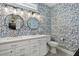 Well-appointed bathroom with dual sinks, modern fixtures, and stylish blue-themed wallpaper at 112 17Th E St, Bradenton, FL 34208