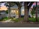 Charming blue two-story home with a bright yellow front door and inviting front porch and mature trees at 112 17Th E St, Bradenton, FL 34208