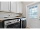 Well-lit laundry room with gray front-loading machines and a windowed exterior door at 112 17Th E St, Bradenton, FL 34208
