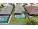 Drone shot of a backyard screened-in pool and deck, and green lawn in a residential area at 11223 Spring Gate Trl, Bradenton, FL 34211