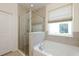 Bright primary bathroom featuring soaking tub with glass shower and large window at 11223 Spring Gate Trl, Bradenton, FL 34211
