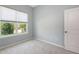 Bright bedroom featuring a window with view, gray walls and plush carpet at 11223 Spring Gate Trl, Bradenton, FL 34211