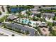 Aerial view of community pool with palm trees, parking and playground near lake and residential homes at 11223 Spring Gate Trl, Bradenton, FL 34211