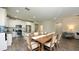 Open-concept kitchen and dining area with stainless steel appliances, white cabinetry, and a large island at 11223 Spring Gate Trl, Bradenton, FL 34211