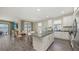 Bright kitchen featuring a granite island with seating, white cabinets, stainless steel appliances, and tile flooring at 11223 Spring Gate Trl, Bradenton, FL 34211