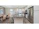 Open kitchen with a granite island, white cabinetry, stainless steel appliances, tile floors, and dining table at 11223 Spring Gate Trl, Bradenton, FL 34211