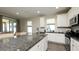 Modern kitchen boasts stainless steel appliances, granite countertops, white cabinets, and a breakfast bar at 11223 Spring Gate Trl, Bradenton, FL 34211