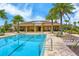 Resort-style community pool with lounge chairs, palm trees, and a clubhouse in the background at 11223 Spring Gate Trl, Bradenton, FL 34211