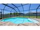 Backyard pool in screened enclosure; beautiful paver patio and well-maintained landscaping beyond at 11223 Spring Gate Trl, Bradenton, FL 34211