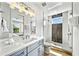 Modern bathroom featuring white countertops, stylish vanity, glass shower, and wood look flooring at 119 Avenida Messina, Sarasota, FL 34242