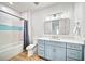 Bright bathroom featuring a blue vanity with white marble countertops and shower and tub combination at 119 Avenida Messina, Sarasota, FL 34242