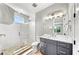 Bright bathroom featuring walk-in shower with textured glass, modern vanity, and stylish lighting fixture at 119 Avenida Messina, Sarasota, FL 34242
